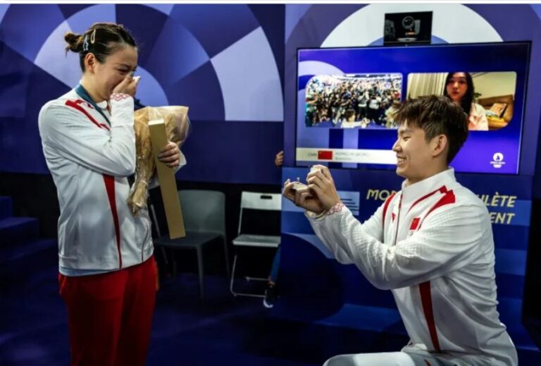 La china Huang Yaqiong (izquierda) recibe una petición de matrimonio por parte del también jugador de bádminton chino Liu Yuchen tras la final del dobles mixto del torneo olímpico de bádmington, en París el 2 de agosto de 2024 (Luis TATO)
